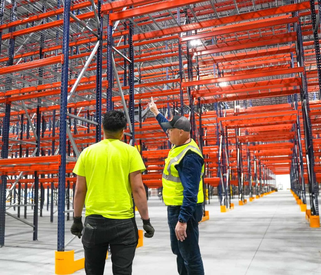 AWS project consultant reviewing tall selective pallet racking with a warehouse client